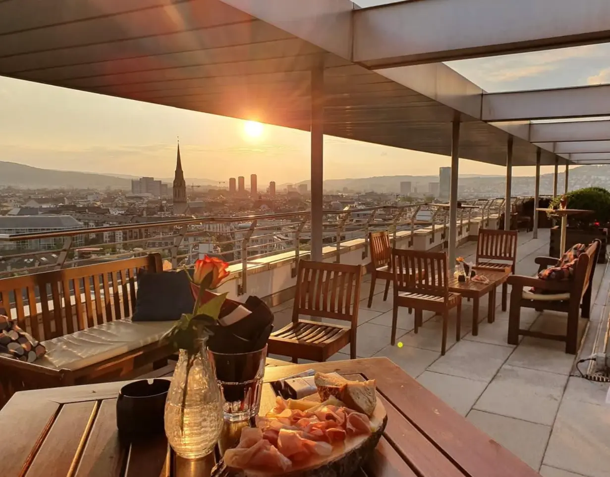 Rooftop-Eventlocation Zürich mit Sonnenuntergang über der Stadt